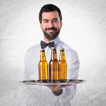Waiter with beer bottles on the trayの写真素材