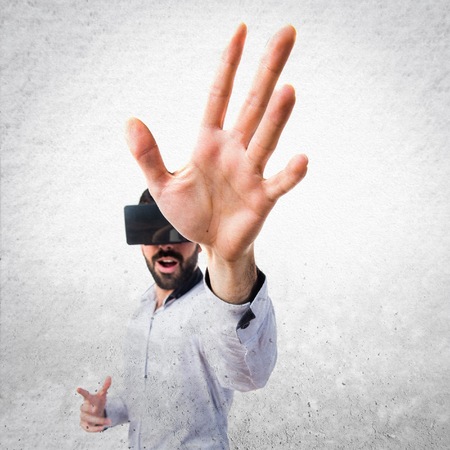 Man using VR glasses touching on transparent screenの写真素材