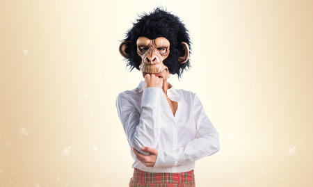 Girl with monkey mask thinkingの写真素材