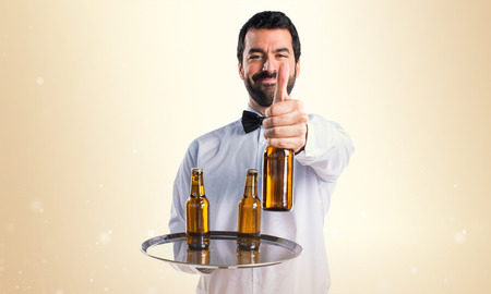 Waiter with beer bottles on the trayの写真素材