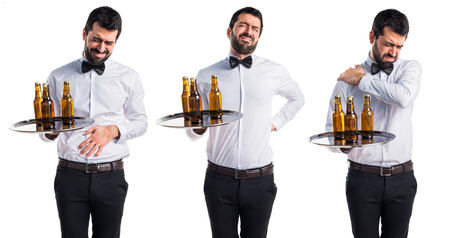 Waiter with beer bottles on the tray with back painの写真素材