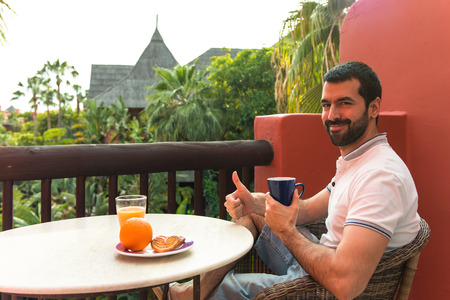 Man having breakfast on hotel terraceの写真素材
