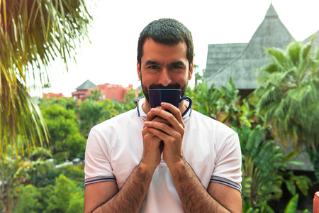 Man drinking coffee outdoorsの写真素材