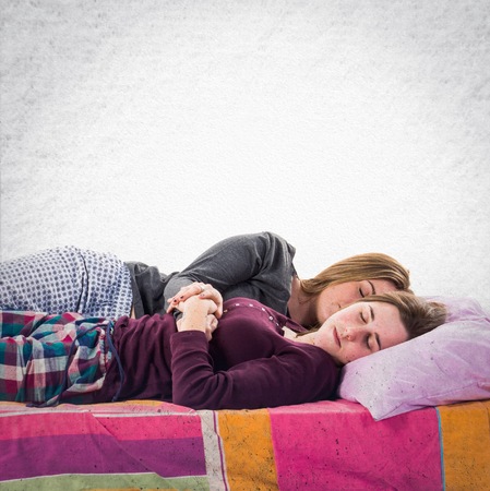 Sisters sleeping on bedの写真素材