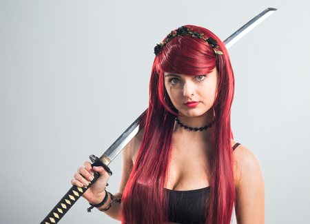 Young redhead girl with katanaの写真素材