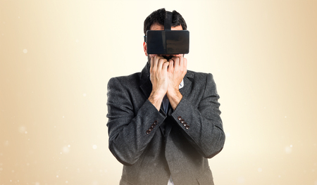 Frightened man using VR glassesの写真素材