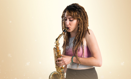 Girl with dreadlocks playing the saxophoneの写真素材