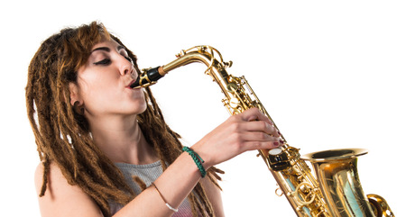 Girl with dreadlocks playing the saxophoneの写真素材