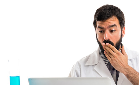 Surprised scientist man working with his laptopの写真素材