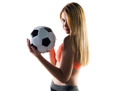 Pretty blonde girl holding a soccer ball