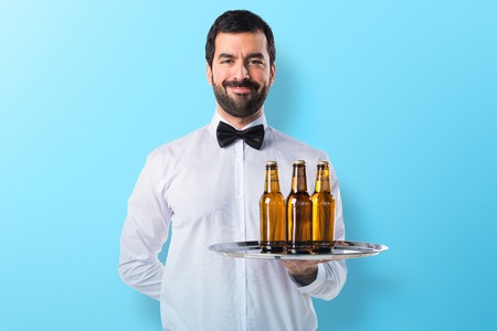 Waiter with beer bottles on the trayの写真素材