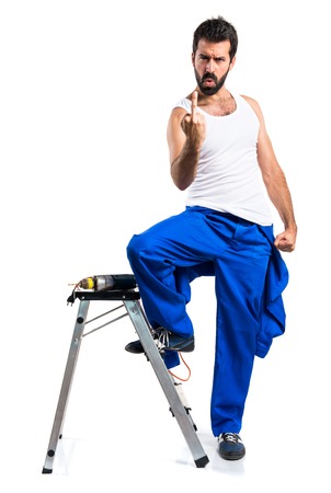 Young electrical technician with a drill making horn gestureの写真素材