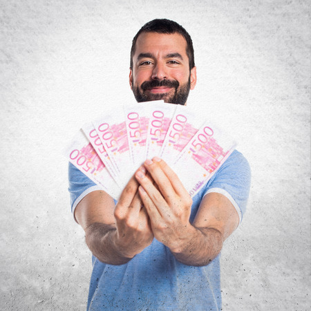 Man with blue shirt taking a lot of moneyの写真素材