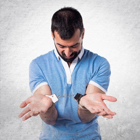 Man with blue shirt with handcuffsの写真素材