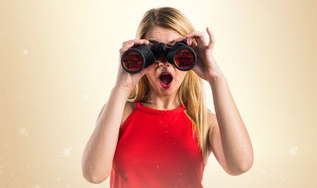 Blonde girl with binocularsの写真素材