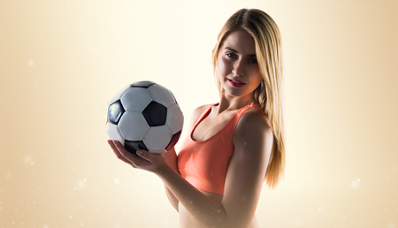 Pretty blonde girl holding a soccer ballの写真素材