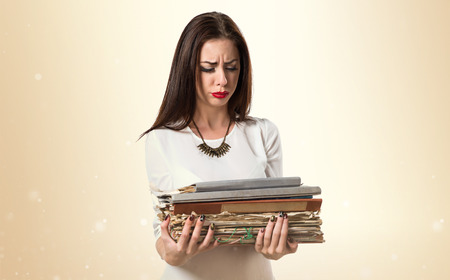 frustrated pretty young girl holding several college notesの写真素材