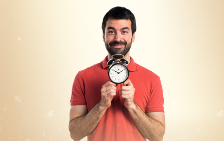 Handsome man holding vintage clock