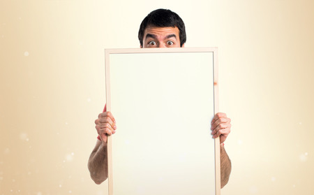 Handsome man holding an empty placardの写真素材