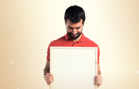 Handsome man holding an empty placardの写真素材