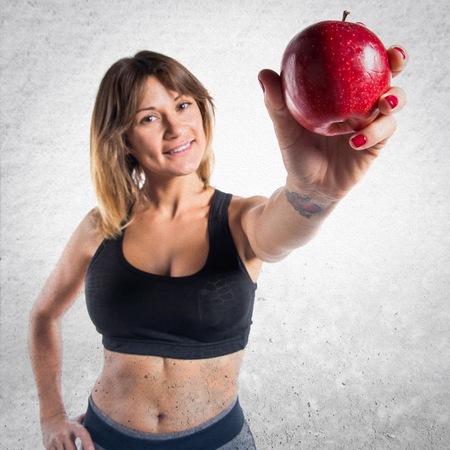 Sport woman showing an appleの写真素材