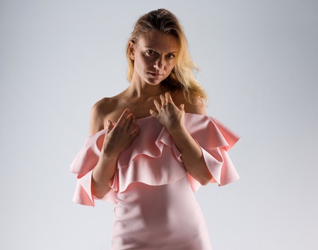 Pretty model woman posing in studio with a pink dressの写真素材