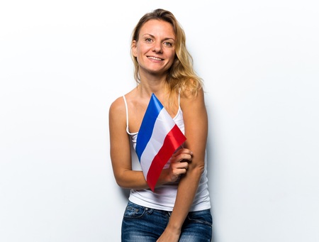 Pretty blonde woman holding a flagの写真素材