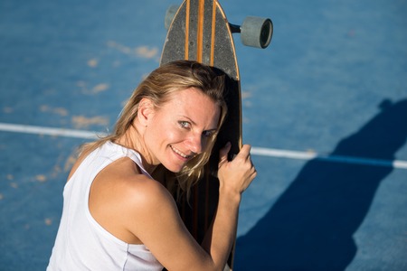 Beautiful woman with longboardの写真素材