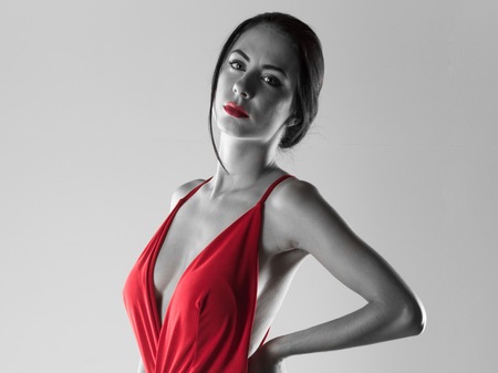 Beautiful model woman posing in studio with a sexy red dress