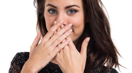 Pretty young girl covering her mouth