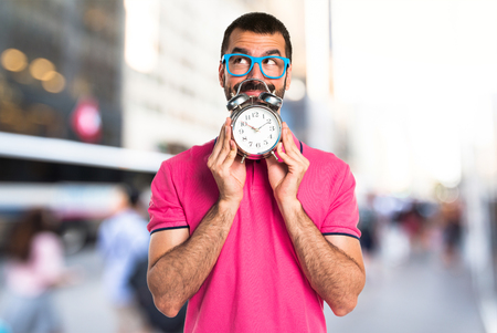 Man with colorful clothes holding vintage clockの写真素材
