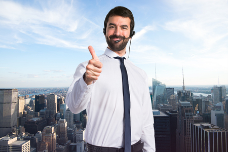 Young man with a headset with thumb upの写真素材