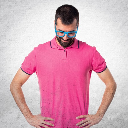 Man with colorful clothes looking down on grey textured backgroundの写真素材