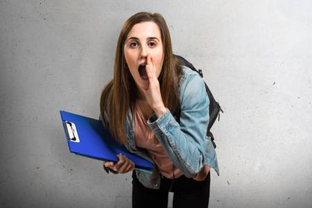 Teen student girl holding books and shoutingの写真素材