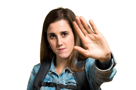 Teen student girl with backpack and making stop sign