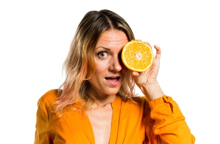 Beautiful blonde woman holding orangesの写真素材