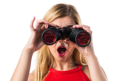 Blonde girl with binocularsの写真素材