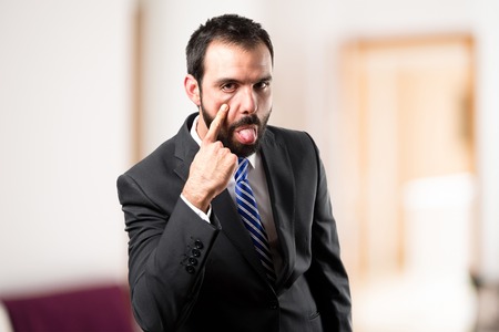 Young businessman making a mockery over white backgroundの写真素材