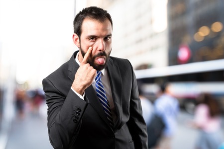 Young businessman making a mockery over white backgroundの写真素材