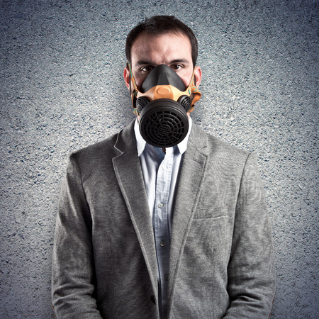 young businessman with gas mask over white backgroundの写真素材