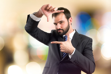 Young businessman doing a frame sign over white backgroundの写真素材