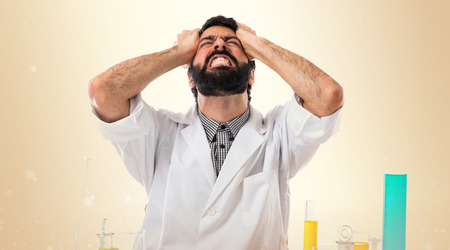 Frustrated scientist man on ocher backgroundの写真素材
