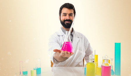 Scientist man with test tubes on ocher background