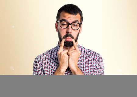 Sad man with glasses on ocher backgroundの写真素材