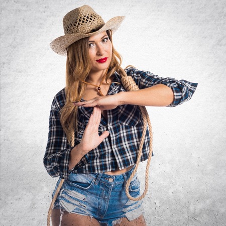 Sexy blonde woman cowgirl making time out gestureの写真素材
