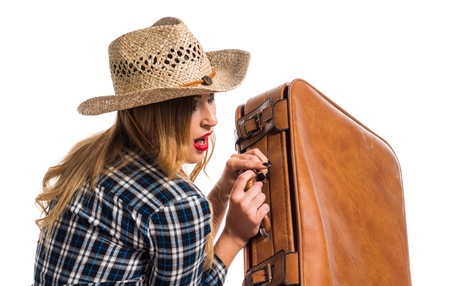 Sexy blonde woman cowgirl with vintage suitcaseの写真素材