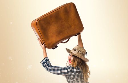 Sexy blonde woman cowgirl with vintage suitcaseの写真素材