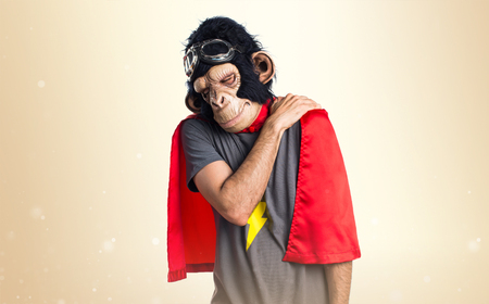 Superhero monkey man with back pain on ocher backgroundの写真素材