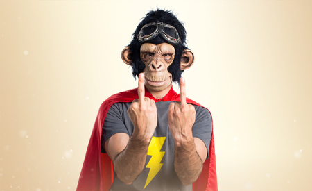 Superhero monkey man making horn gesture on ocher backgroundの写真素材