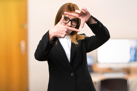 Young business woman focusing with her fingers on unfocused backgroundの写真素材